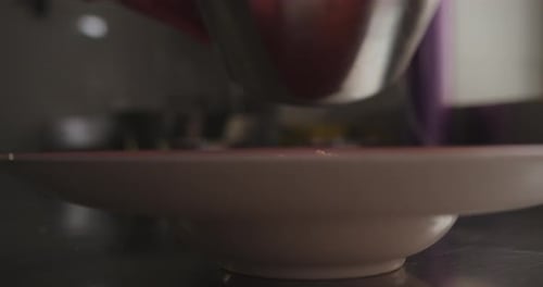 Beautiful slow motion, sideways shot of a dish while serving "octopus casserole" with a spoon inside