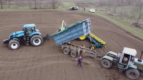 Blue tractor OA working on the field in Ukraine