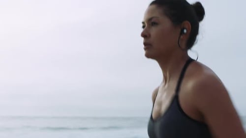 Woman, music earphones or running by beach, ocean or sea in cardiology wellness