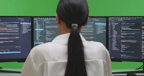 Tired Asian Woman Developer Yawning While Write Code With Multiple Screens In Green Screen Studio
