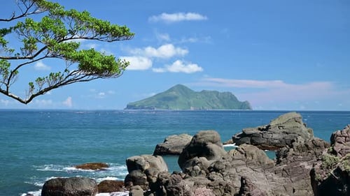Mar azul e céu azul com nuvens brancas em mudança. Pequenas ilhas e rochas.