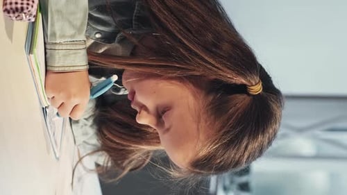 Girl Drawing With Blue Marker in Notebook