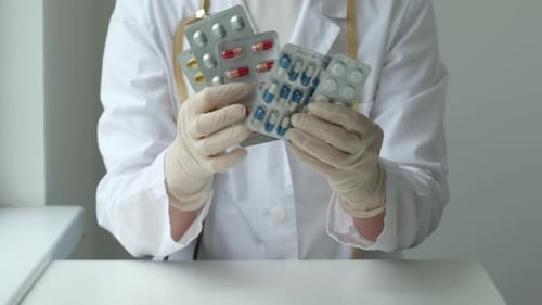 Female Doctor Showing Different Pills at Clinic Health Care Pharma Medicine