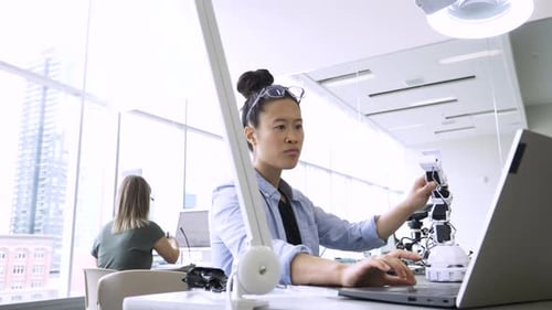 Female Engineer Assembling Robotics at Laptop in Science Laboratory Adult