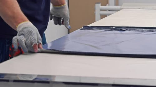 Craftsman Applying Blue Film to Surface