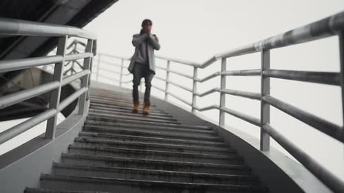 Man Walks Down Staircase in Urban Setting