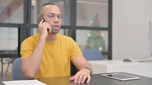 Young Man Talking on Phone in Office