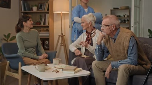 Adult Woman Talking with Seniors at Their Home