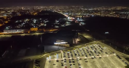 aerial night hyperlapse timelapse of stadium of chisinau arena with fast moving cars on road and par