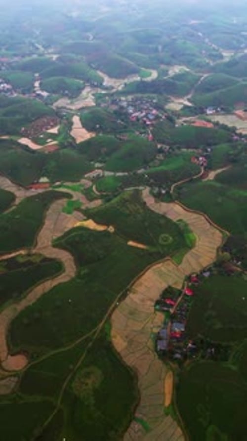 Vertical Overhead View of Tea Plantation Hills and Flooded Rice Paddies by Rural Village Vietnam