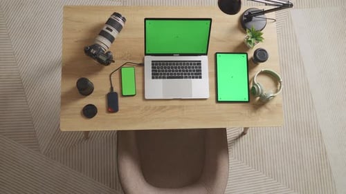 Vue du dessus de l'ordinateur portable, du smartphone et de la tablette à écran vert à côté de la caméra sur une table