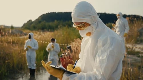 Scientists Wearing Hazmat Suits Researching Water Sample