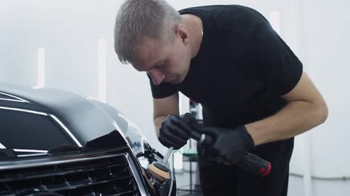 Man Polishing Car with Electric Polisher