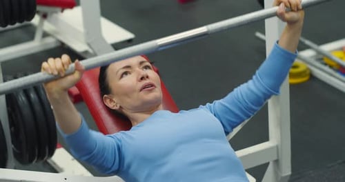 Woman Bench Pressing in Gym for Strength Training