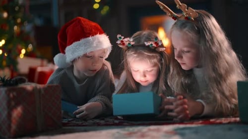 Excited Children Opening Magical Christmas Gift