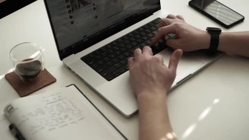 Man Typing on Laptop at Desk