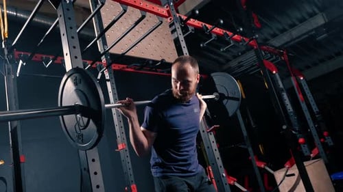 young motivated bodybuilder squatting with heavy barbell in gym exercise active lifestyle body care