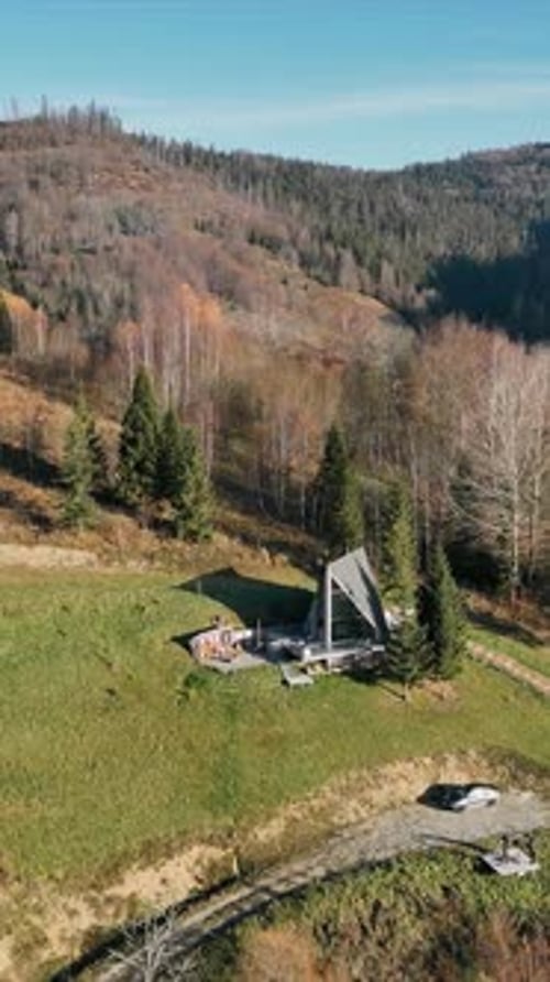 Hillside AFrame Cabin with Scenic Views Aerial View of an Aframe Cabin on a Grassy Hillside