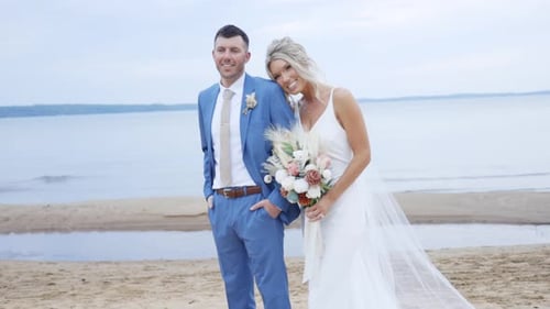 Gorgeous bride and groom laughing together on the beach during golden hour