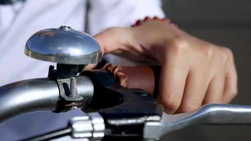 Person Ringing Bicycle Bell on Bike Handlebars, Closeup