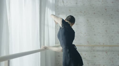 Graceful Woman Practicing Ballet at the Barre