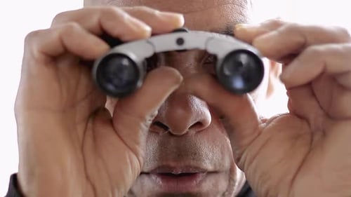Man Looking Through Binoculars Close Up Indoors