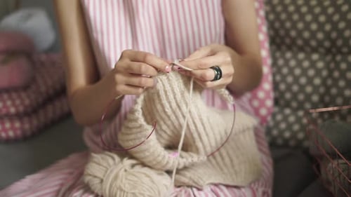 Close Up Female Knitting Hands. Woman Knitting Woolen Sweater Sitting On Couch