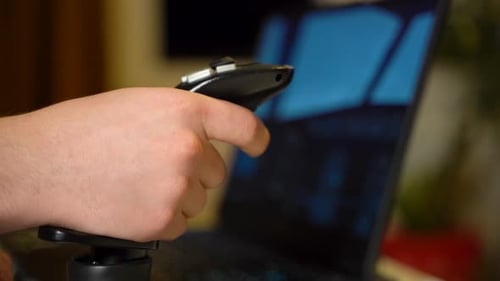 Close up of a person's hand using a precision gaming joystick for flight simulation training.