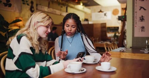 Friends, women and smartphone at cafe for coffee date or lunch with smile for bonding