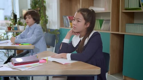 Elementary School Class Children Communicate with the Teacher Answering Question