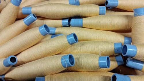 Pile of Beige Thread Spools Close Up