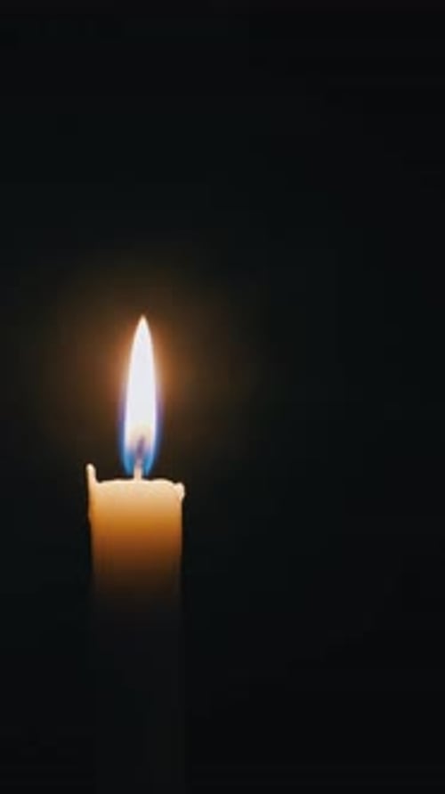 Candle Being Lit with a Match in Darkness
