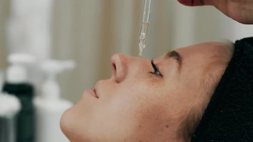 Applying the Serum to the Face Using a Dropper