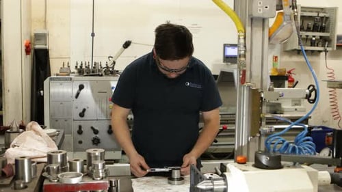 Travailleur industriel mesurant avec un micromètre dans une usine de fabrication
