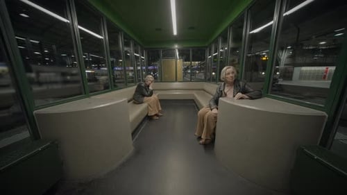 Senior Woman Waiting in Train Station at Night