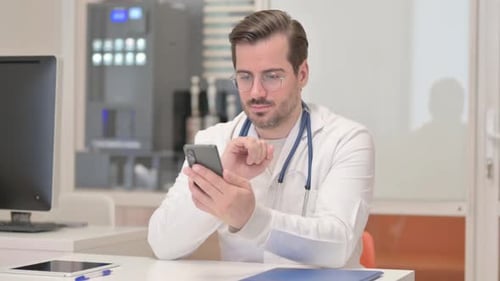 Doctor Using Smartphone at Desk in Office