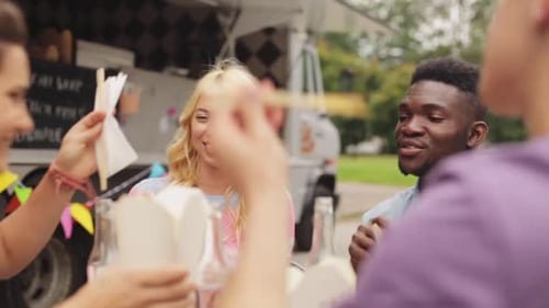 Friends Enjoying Food From Food Truck Outside