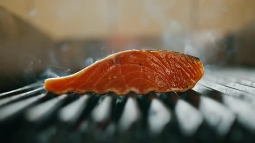A professional kitchen in a hotel restaurant close-up of a juicy piece of fresh salmon on the grill