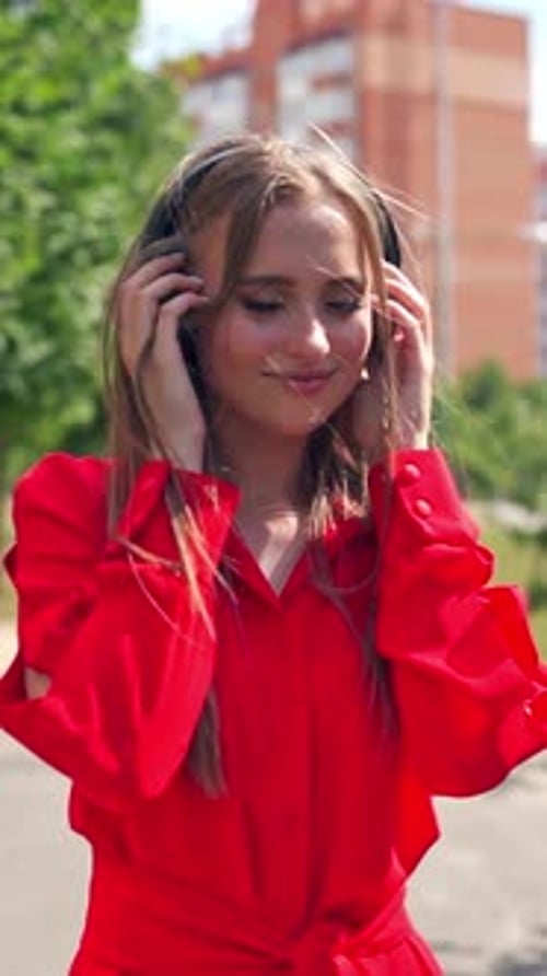 Woman Enjoys Music with Headphones in Urban Setting
