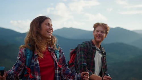 Smiling Couple Hiking with Backpacks in the Mountains