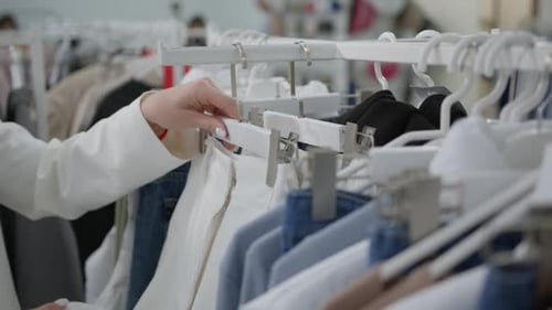 Female Hands Choose White Pants Before Buying