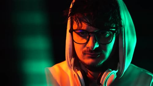 Portrait of Hacker or Programmer in Front of Computer Screen in Dark Room, Close Up