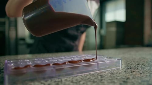 Filling chocolate mold with liquid chocolate