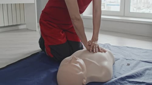 Woman Demonstrating CPR on Mannequin in Bright Room