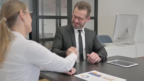 Business Agreement Handshake in Office Setting