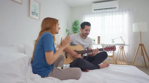 Diverse young couple spending free leisure time together in cozy room.