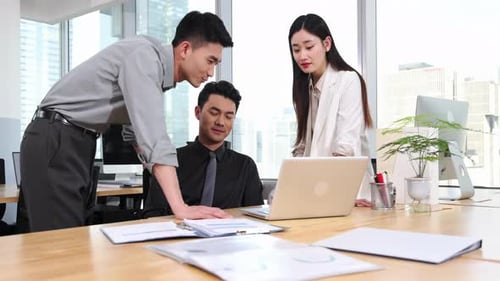 Team of Colleagues Discussing Work at Desk