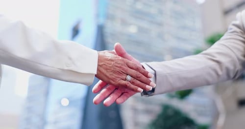 Handshake, partnership and business people in city, agreement and collaboration with support