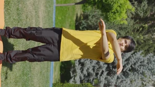 Vertical Video of Young man exercising outdoors, arm exercises.