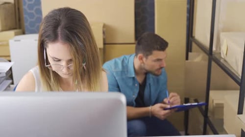 Female Marketer Using Computer While Checking Orders In E-Commerce Store.